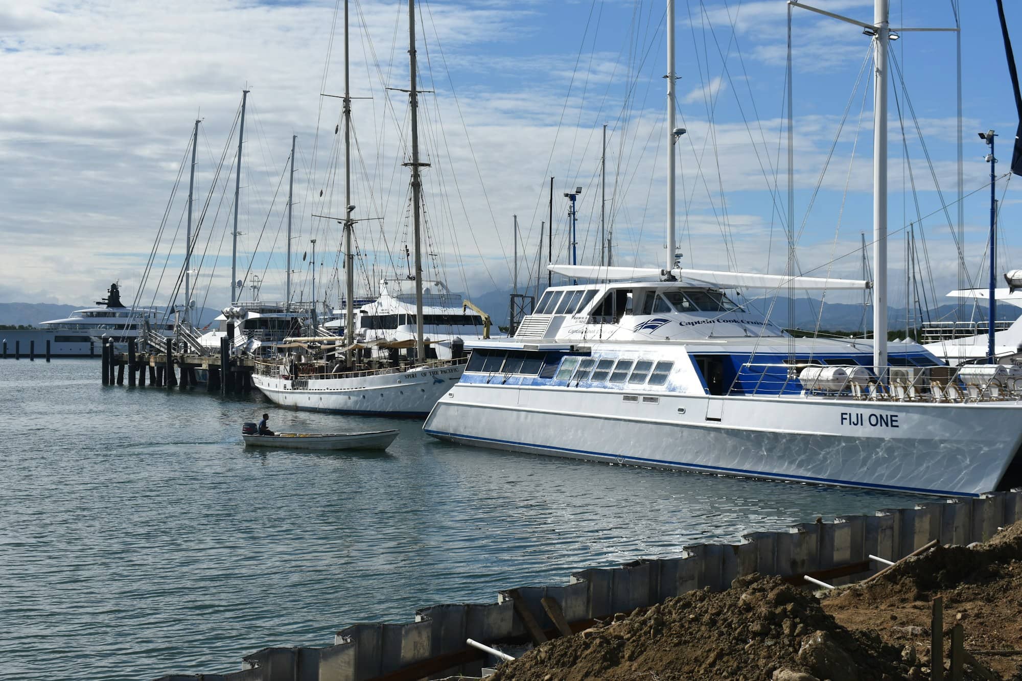 Boats docked in a harbor under a cloudy sky.