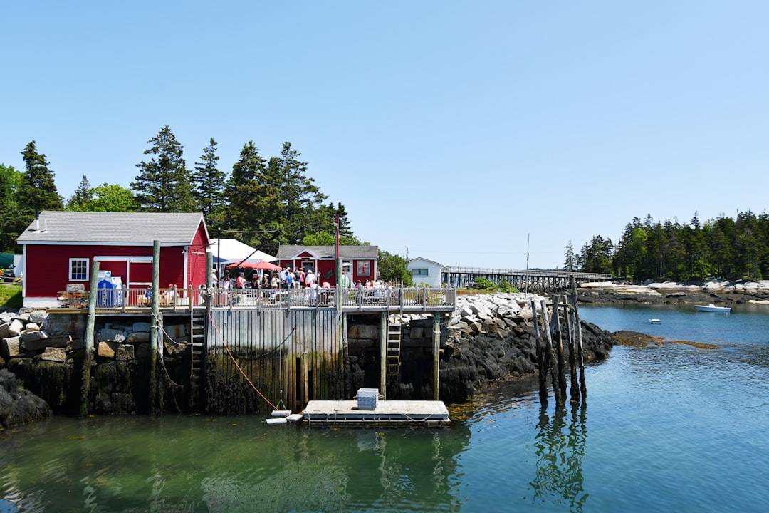 A red building sits on a wooden dock.