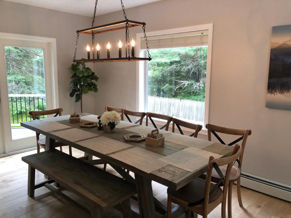 a dining room with a table with chairs and a chandelier at The Mighty Oaks Retreat,modern house Bar Harbor Acadia MDI in Bar Harbor