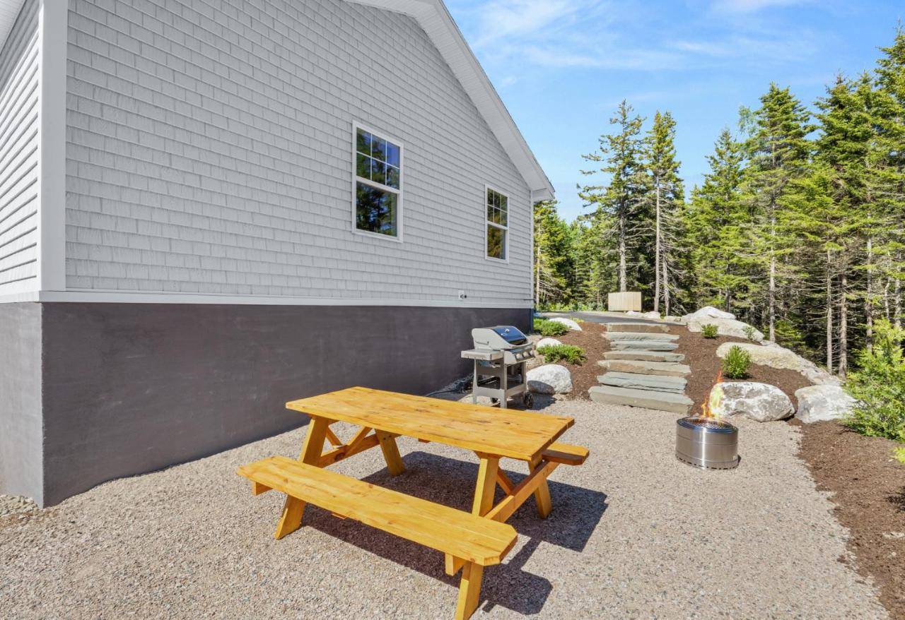 a wooden picnic table in front of a house at Huckleberry Hollow - Private Retreat in Bernard
