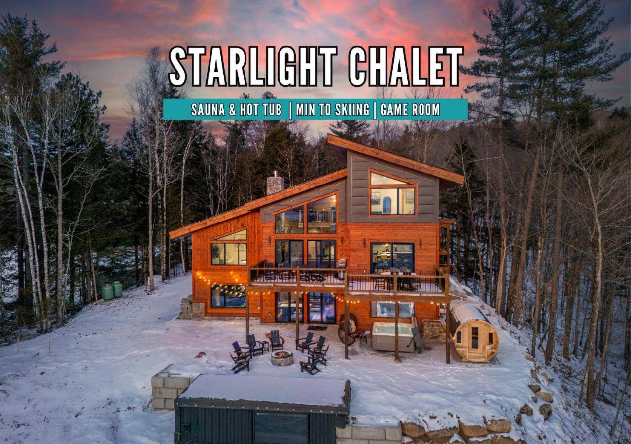 a house in the woods with snow on the ground at Epic Views, 9Mi SR, GameRmTheater, HTub, Sauna in Bethel