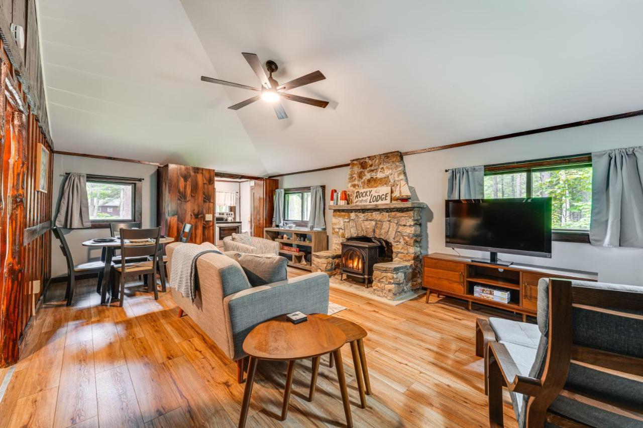 a living room with a fireplace and a tv at Walk to Barretts Park Wooded Cabin with Grill! in Boothbay Harbor