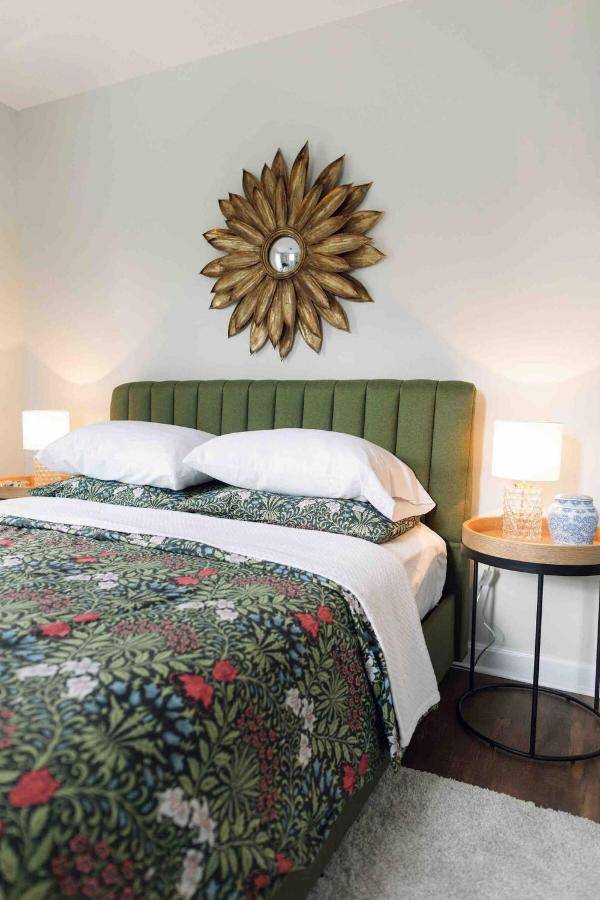 a bedroom with a bed and a mirror on the wall at Sea Fog Cottage in Camden