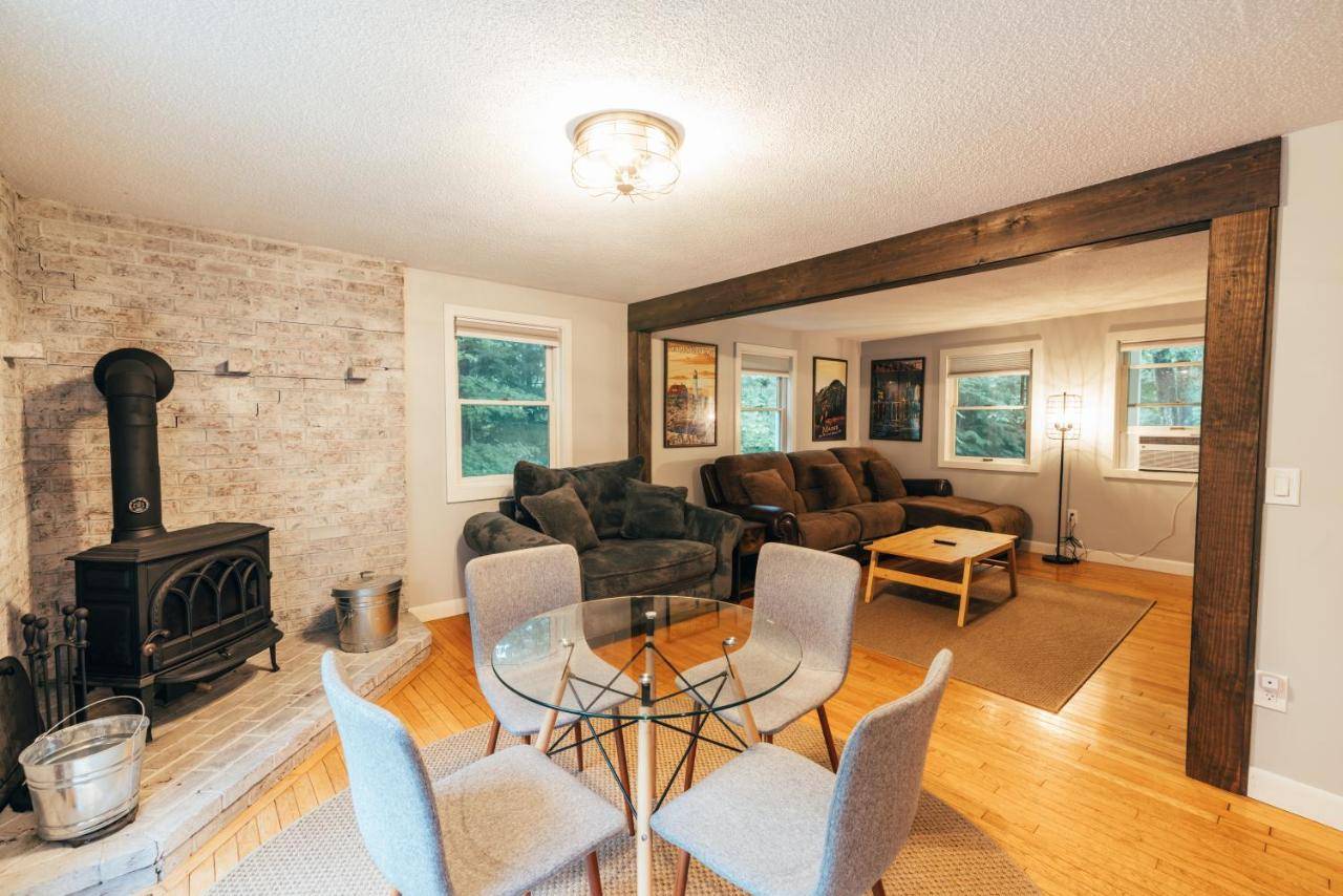 a living room with a fireplace and a table and chairs at Spacious Country Home Freeport, 5 min to LL Bean! in Freeport