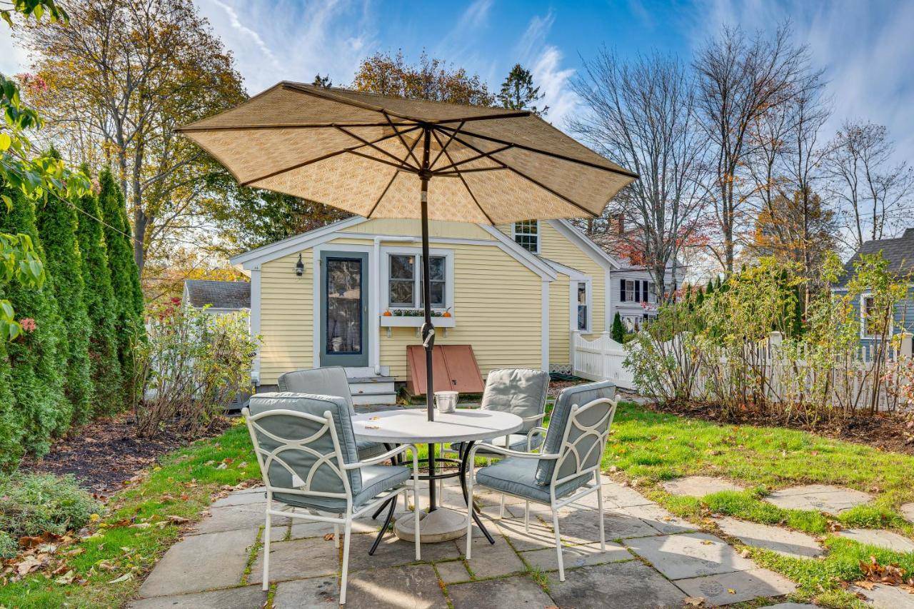a table and chairs with an umbrella in a yard at Less Than 1 Mi to Beach! Kennebunk Cottage with Yard in Kennebunk