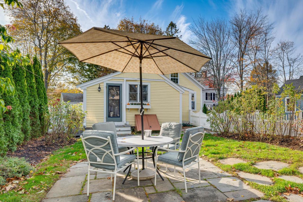 a table and chairs with an umbrella in a yard at Less Than 1 Mi to Beach! Kennebunk Cottage with Yard in Kennebunk