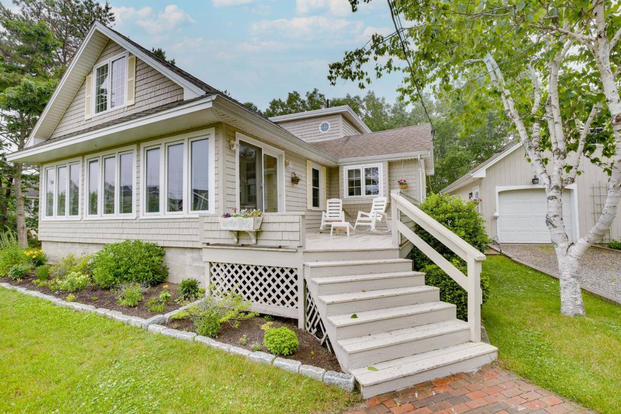 a small white house with a porch and stairs at Kennebunkport Getaway with Grill Walk to Beach! in Kennebunkport