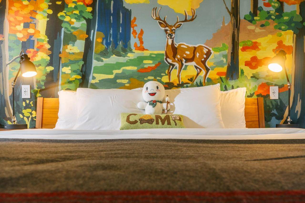 a bed with a teddy bear sitting on top of it at Camp DeForest in Lincolnville