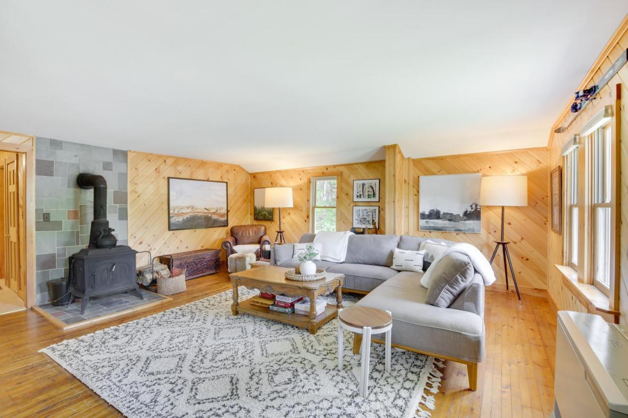 a living room with a couch and a fireplace at Gorgeous Sunday River Cabin with Saltwater Hot Tub! in Newry
