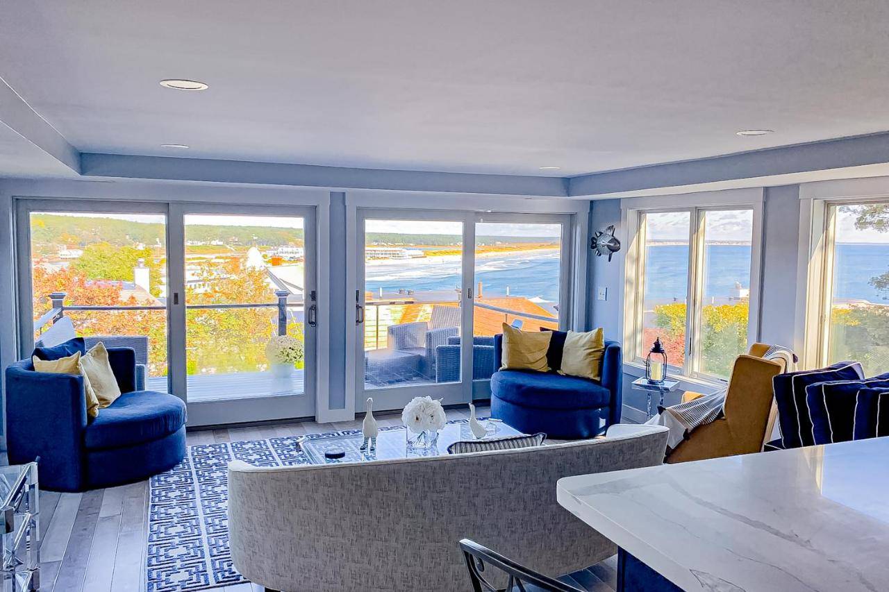 a living room with blue chairs and a table at Ocean Escape in Ogunquit