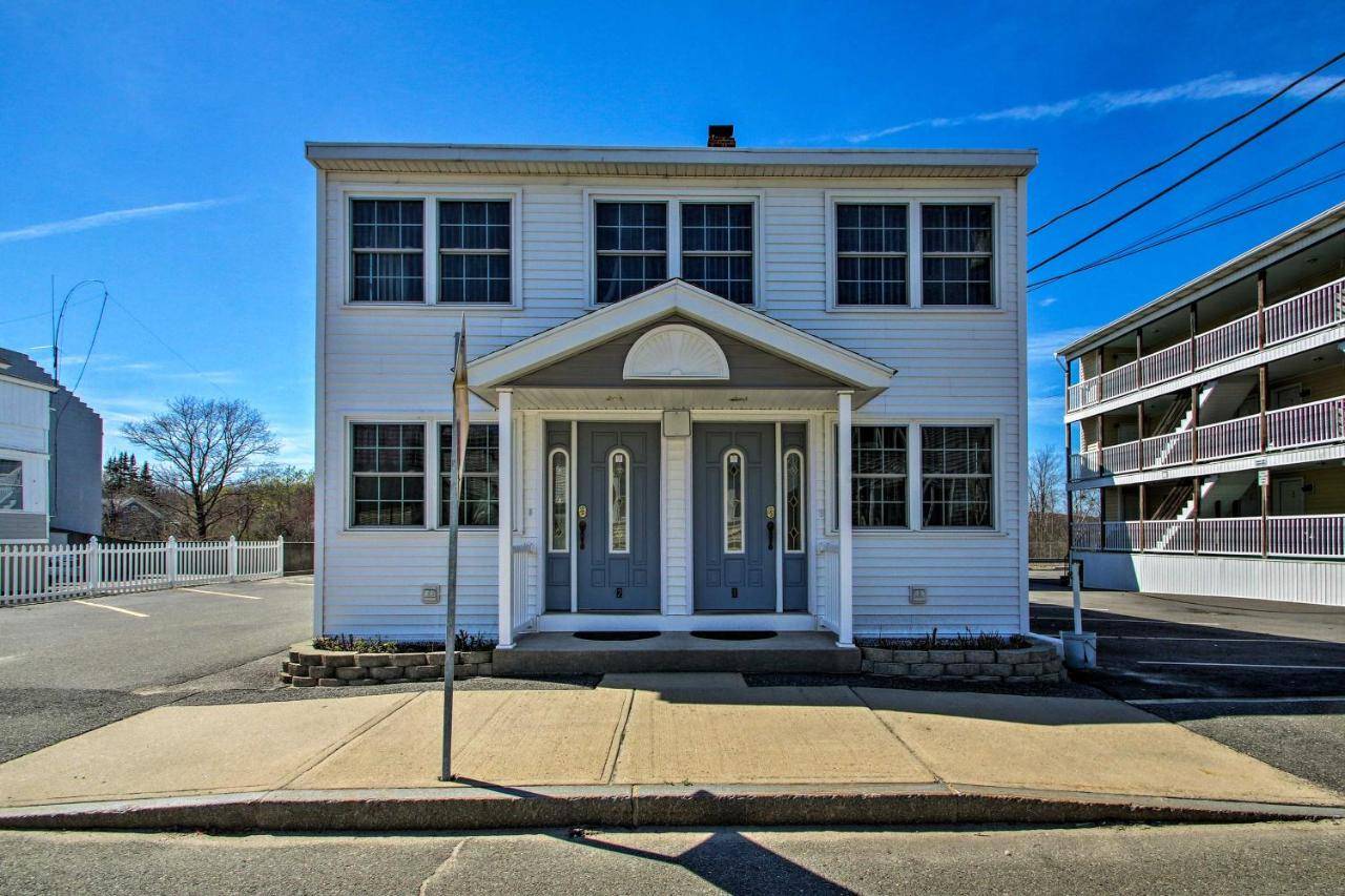 a white house with a blue door on a street at OOB Apt - 1 Block to Bay, Half-Mile to Pier! in Old Orchard Beach