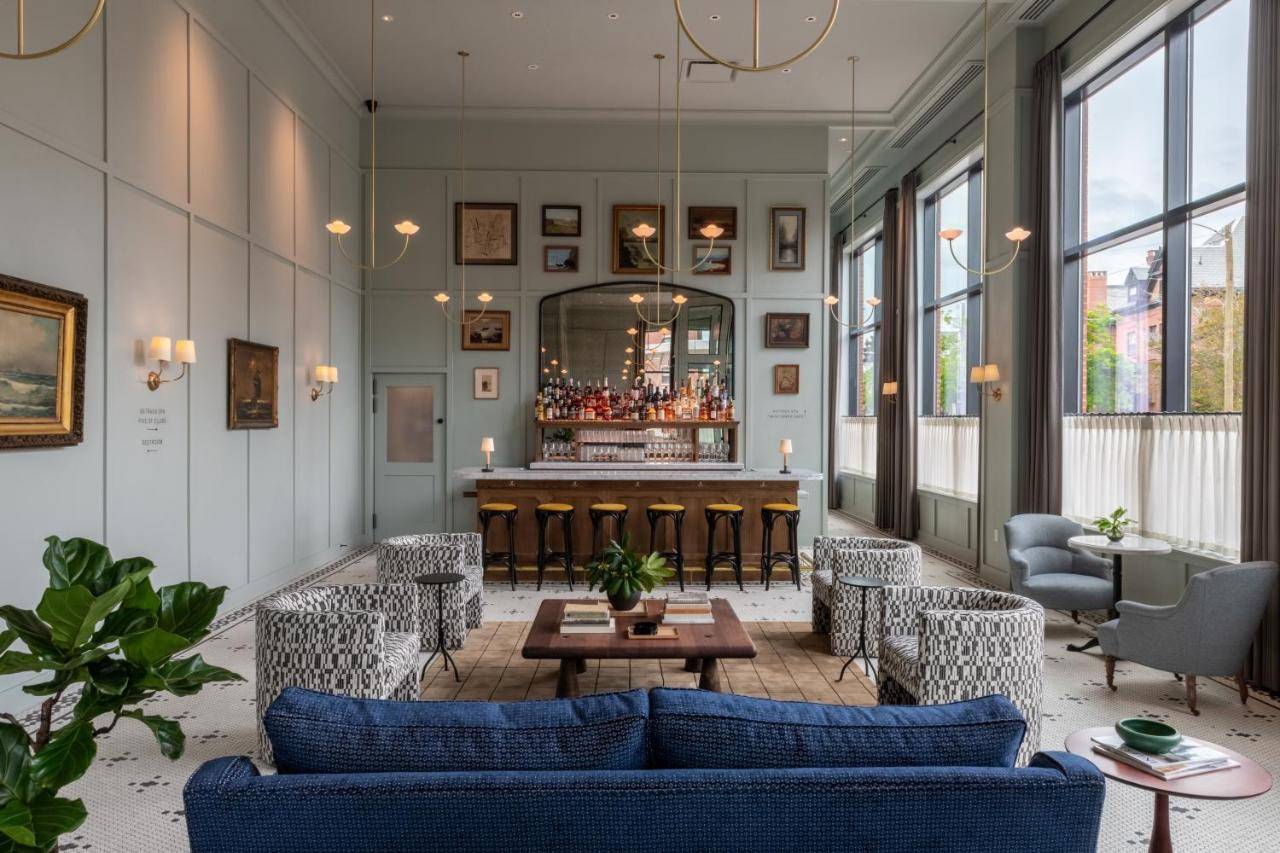 a lobby with a bar and blue couches at Longfellow Hotel in Portland