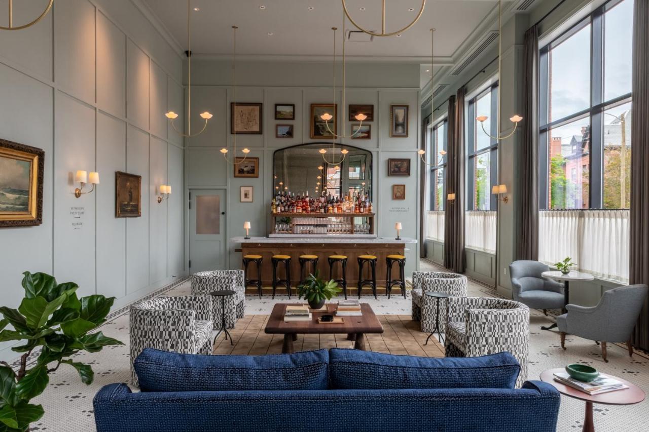 a lobby with a bar and blue couches at Longfellow Hotel in Portland