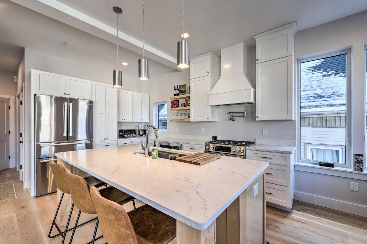 a kitchen with white cabinets and a large island at Spacious Portland Home Walk Downtown! in Portland
