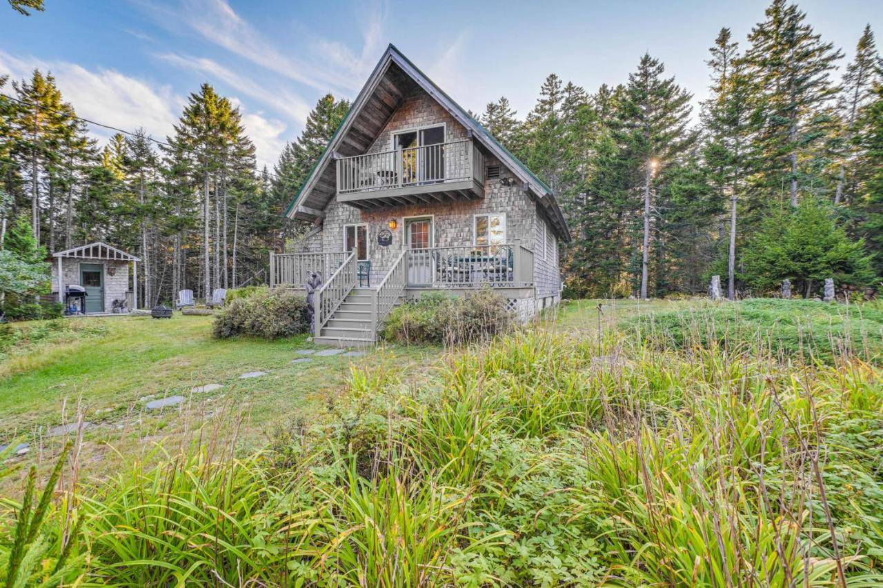 a house on a hill in the middle of a field at Cozy Acadia Area Cabin, Walk to Beach and Lighthouse in Prospect Harbor