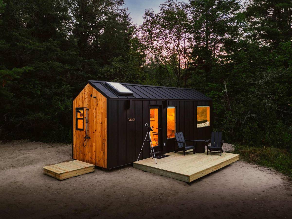 a black tiny house with a table and chairs at Vesta Nook With Shower Queen Bed & pullout sofa in Sullivan